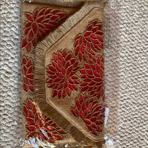 Tan clutch with red embellished flowers
